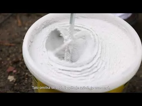 Bílá stříkaná omítka se aplikuje na povrch pomocí trysky.