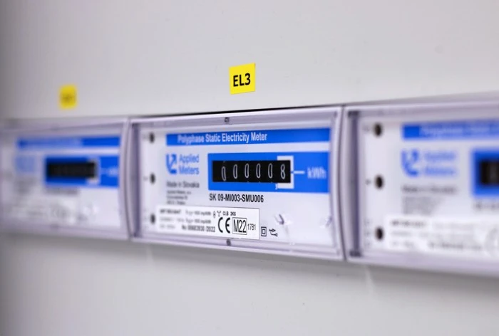 Řada průmyslových elektroměrů namontovaných na zdi s čitelným displejem.