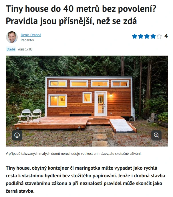 Malý dům v lese s terasou a rampou pro invalidní vozíky.