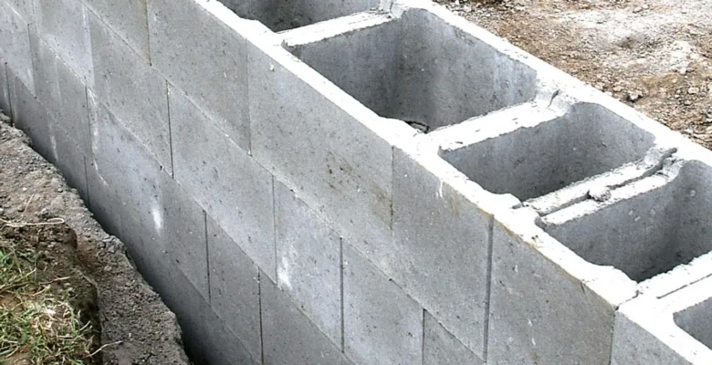 Stavba zdi ze železobetonových bloků na stavbě.