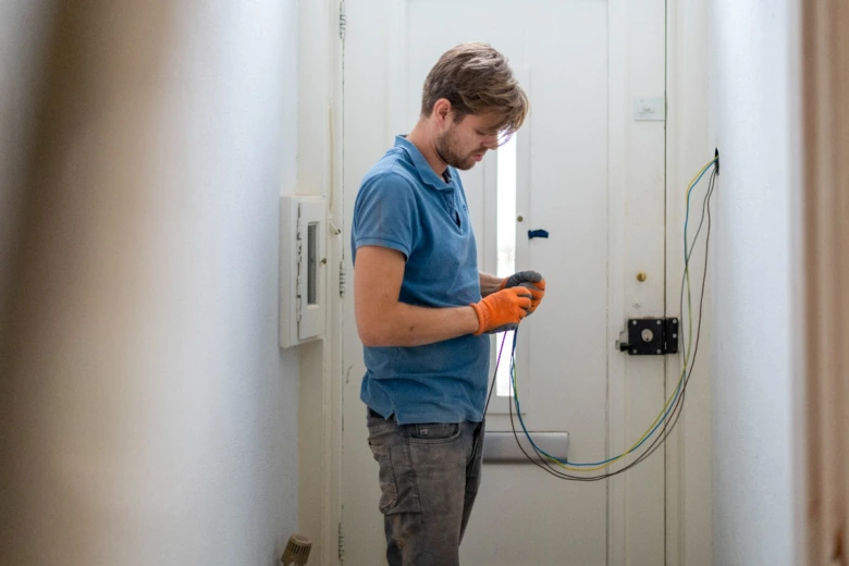 Elektrikář pracuje na instalaci v domácnosti s dráty.