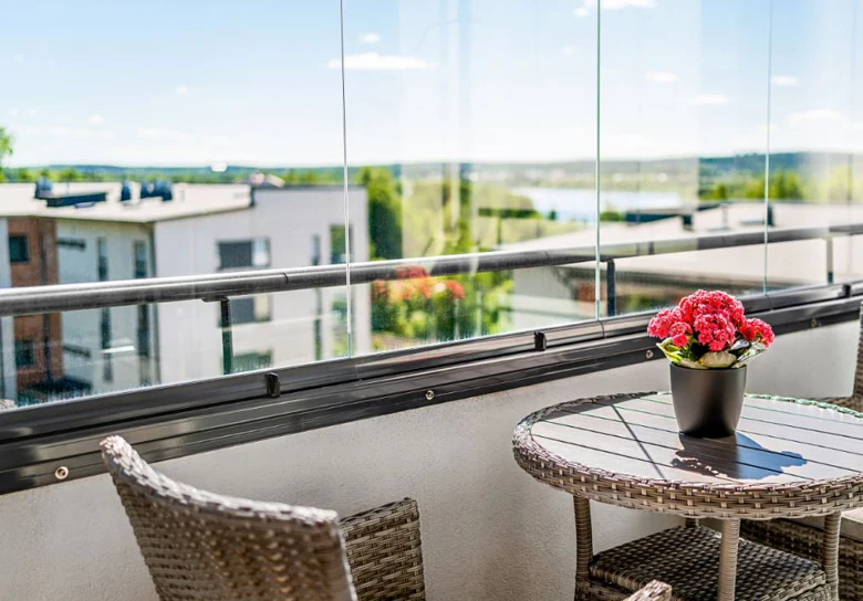 Moderní balkon s průhledným skleněným zábradlím.