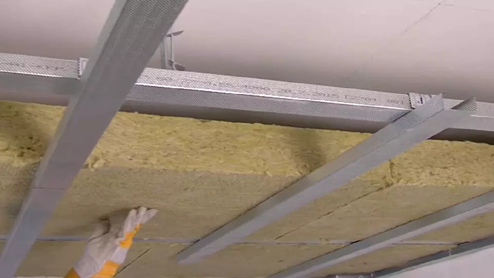 Práce na vnitřním zateplení s izolací mezi nosníky.