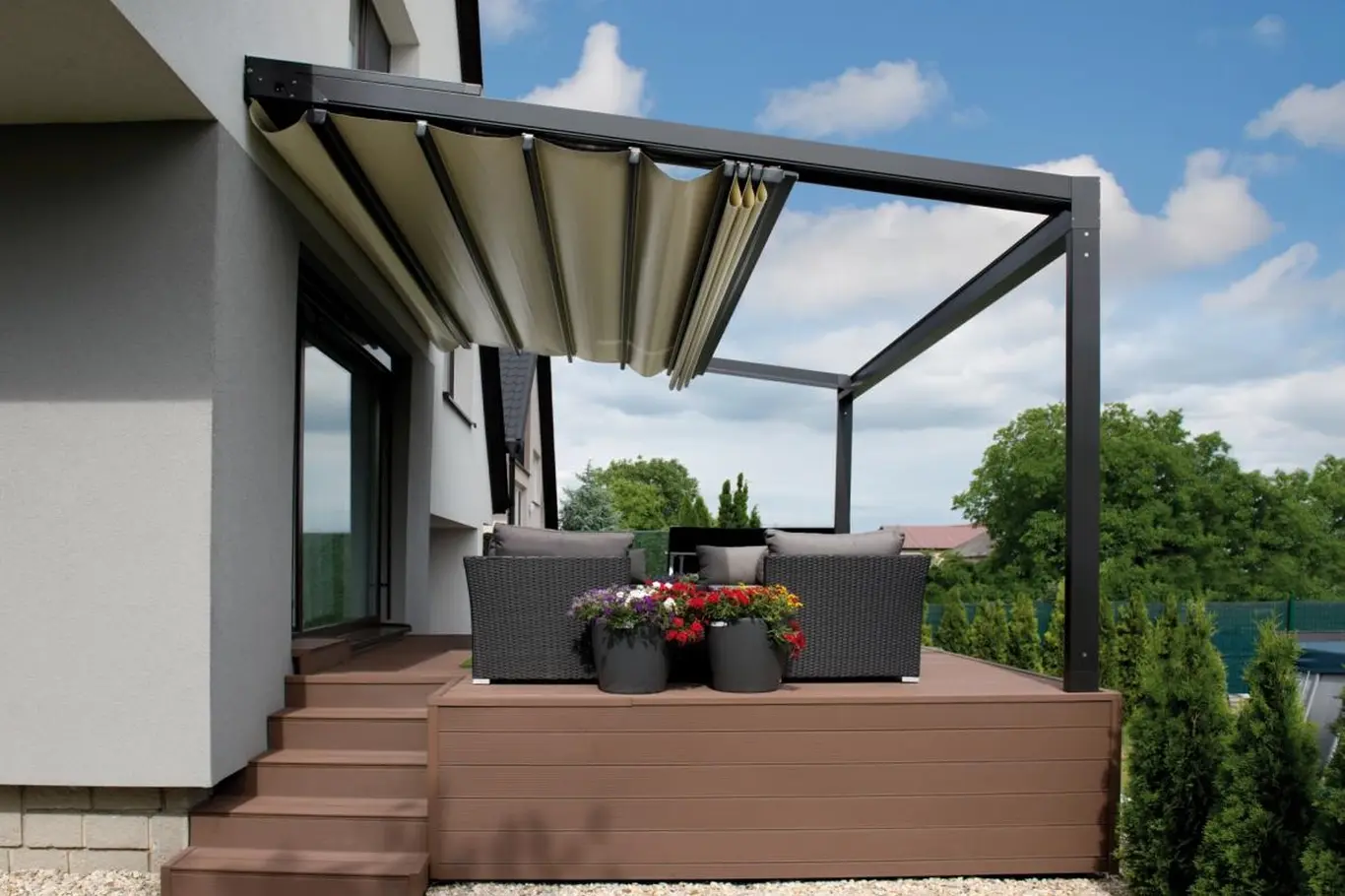 Moderní hliníková pergola s rolojící stínicí plachtou na zahradě.