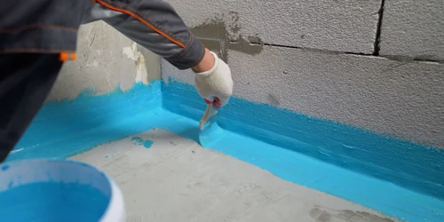 Nápis hydroizolační barvy do kouta koupelny štětcem.