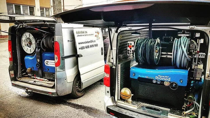 Dva nákladní vozy s vybavením pro údržbu stoupaček v bytě.