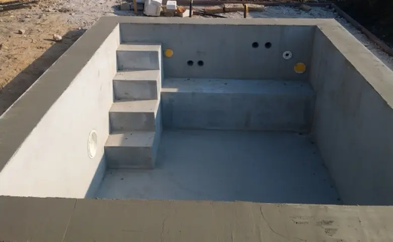 Nově postavený betonový bazén s vnitřními schody.