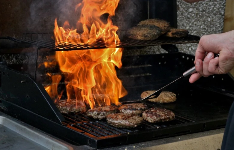Grilování burgrů na zahradním grilu v plameni