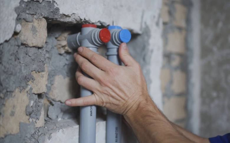Ruční instalace plastových vodovodních trubek v zdi