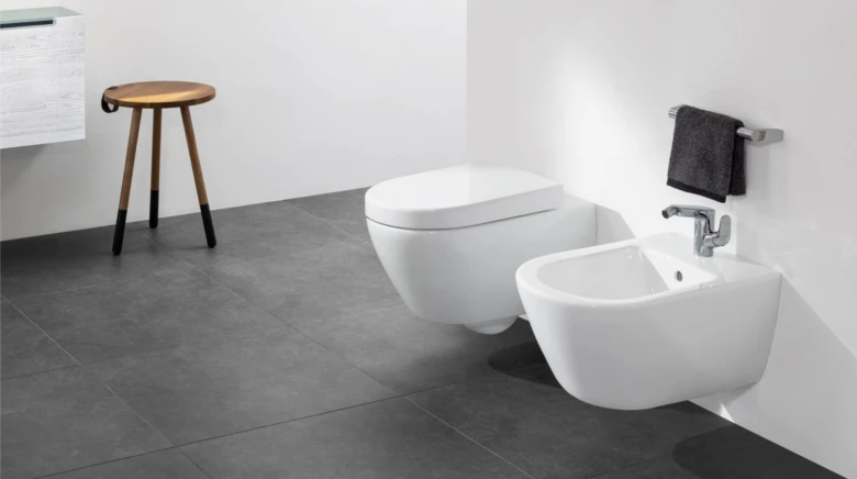 Bílý nástěnné bidet vedle záchodu v moderní koupelně.