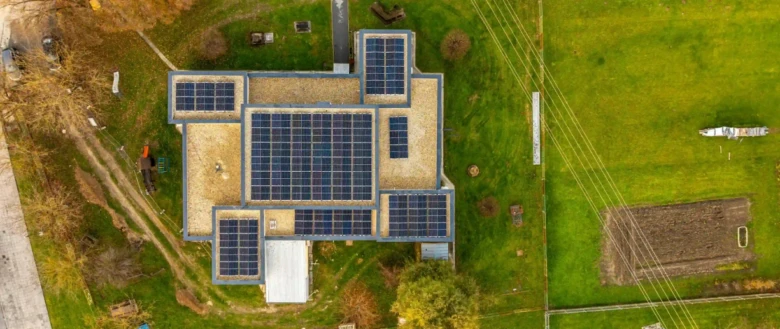 Vzdušný pohled na dům s fotovoltaickými panely instalovanými na střeše.