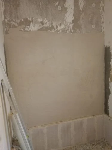 Kout stěny s nanesenou sádrovou stěrkou v průběhu práce.