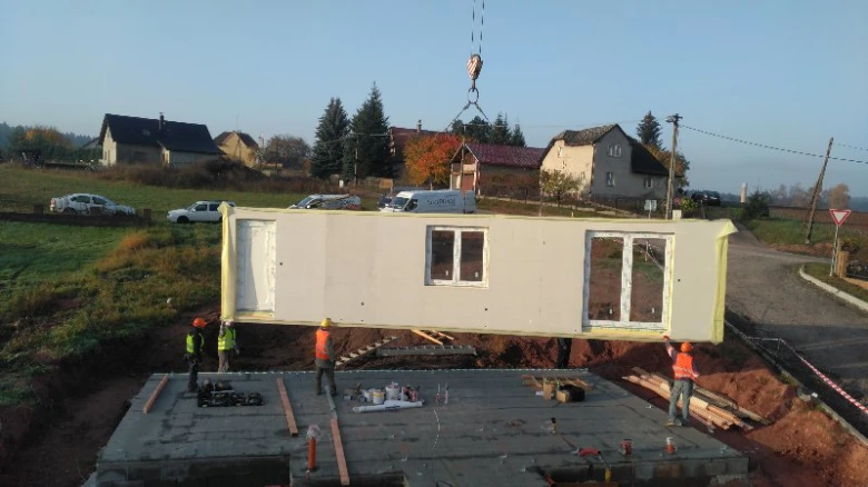 Montáž prefabrikovaného dřevostavby na klíč pomocí jeřábu.
