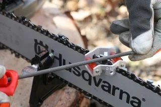 Ruční bruska řetězu motorové pily značky Husqvarna v akci.