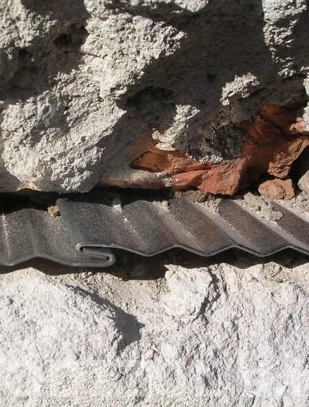 Detail podřezu zdiva s hydroizolační lištou u základu domu.