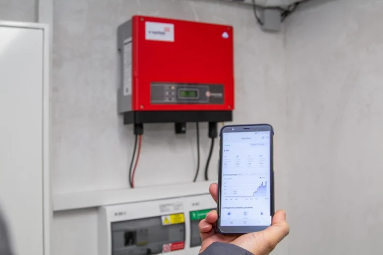 Mobilní telefon s aplikací pro sledování výkonu solárního systému.