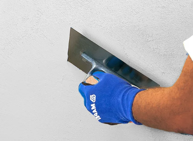 Plastering wall with trowel