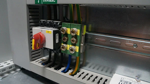 Vnitřní zapojení elektrického rozvaděče s přepínači a vodiči.