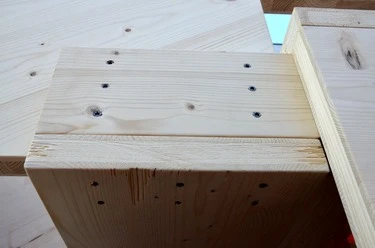Detail dřevěného schodiště s viditelnými šrouby.