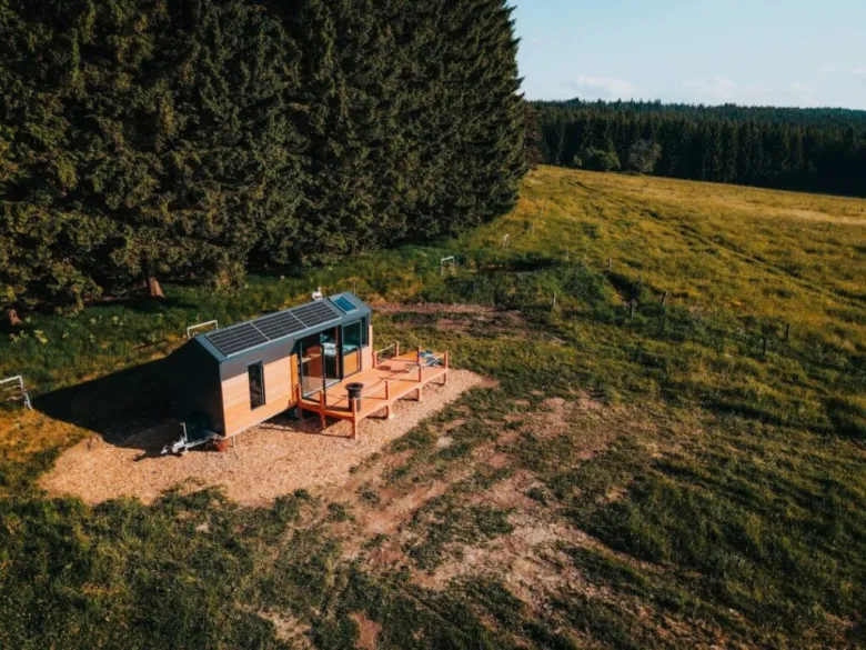 Wheeled tiny house on grassy hillside