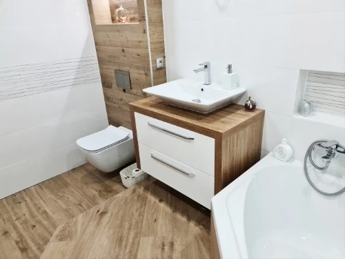 Moderní koupelna s dřevem a bílým vybavením