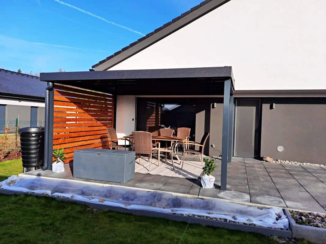 Dřevěná pergola s lavičkou na terase domu.