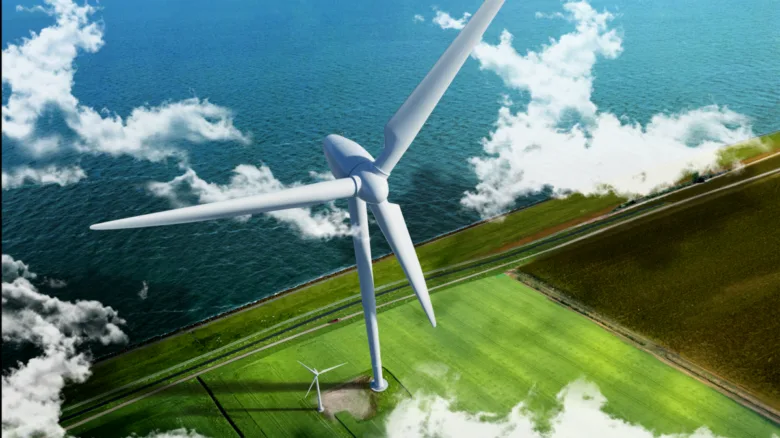 Velká větrná turbína na pobřeží u moře s menší turbinou v pozadí.
