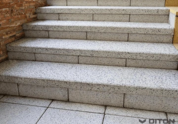 Venkovní betonové schody vedoucí k zdi.