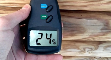 Digitální měřič vlhkosti dřeva ukazuje hodnotu 24 procent.