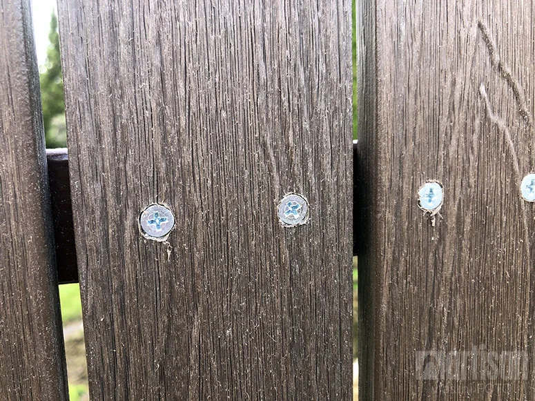 Detailní pohled na montáž panelů z kompozitového dřeva s viditelnými otvory pro šrouby.