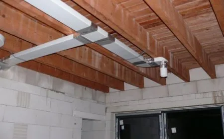 Instalace rekuperační jednotky s potrubím na dřevěných trámech.