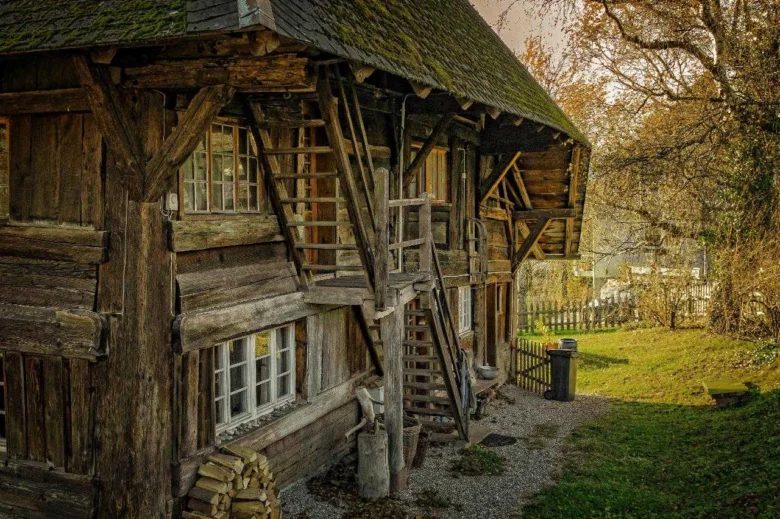 Stará dřevěná stavba s viditelnými trámy pro svépomocnou výstavbu.