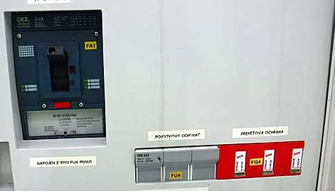 Fotografie rozvaděče s hlavním vypínačem a dalšími jističi v průmyslovém prostředí.