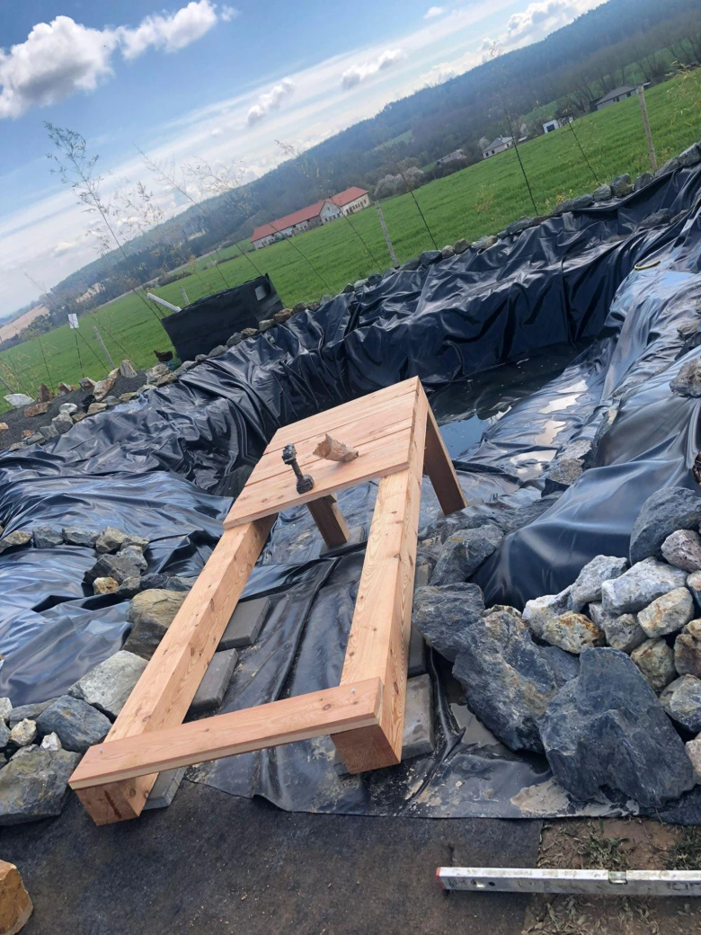 Dřevěný rám na černé fólii v bazénu při stavbě