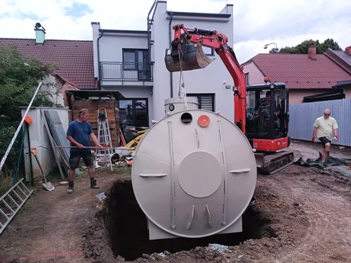 Instalace velké retenční nádrže na vodu pomocí výkopového stroje.