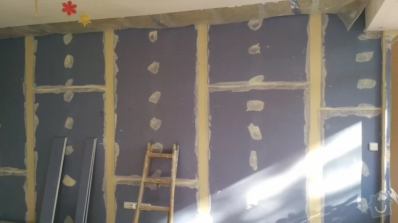 Fialové sádrokartony na kovovém rámu během instalace ve stavebnictví.