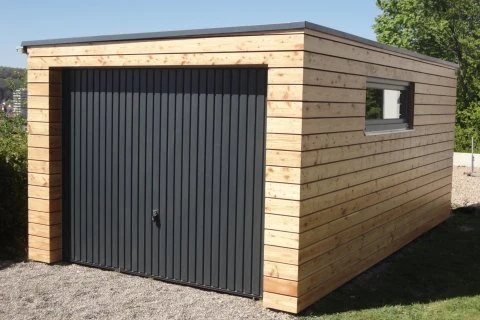 Modern dřevěná garáž s tmavými dveřmi na štěrku.