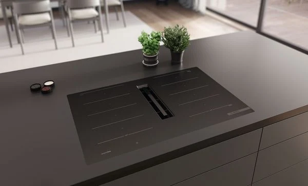 Indukční varná deska s integrovaným odsáváním v moderní kuchyni.