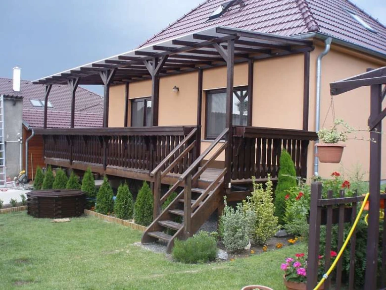 Dřevěný balkon s schodištěm na domu.