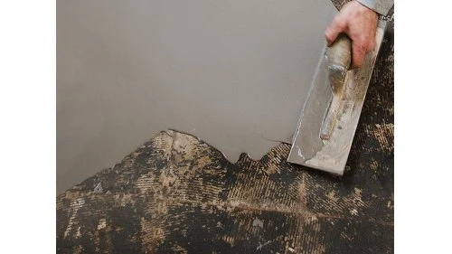 Práce s samonivelační stěrkou na dřevěném podkladu.