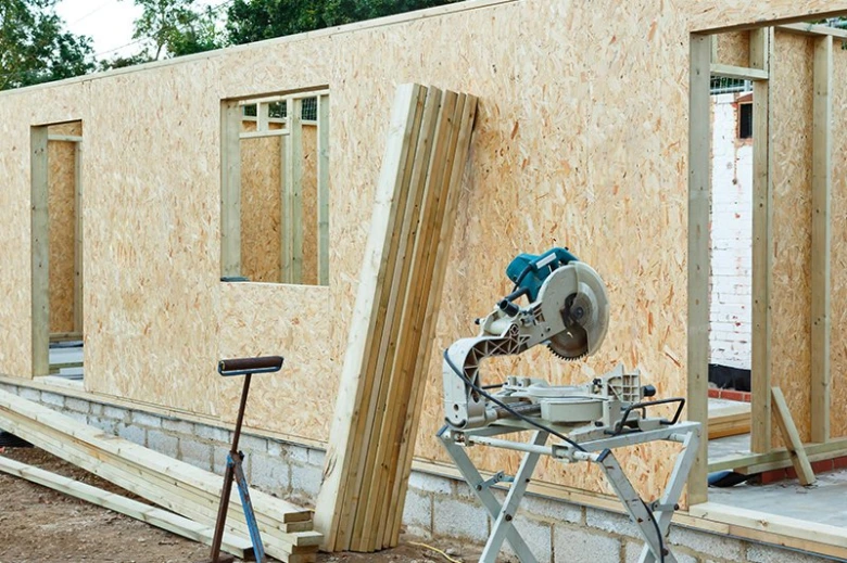 Stavba domu s dřevotřískovými deskami OSB na fasádě.