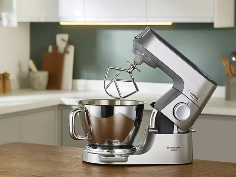 Stříbrný kuchyňský robot s mýdlovým míchacím nástavcem v kuchyni.