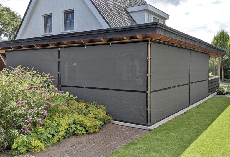 Moderní pergola s tmavou plachtou pro stínění venkovního prostoru.