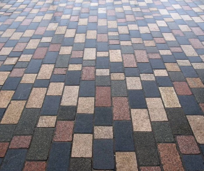 Hotový povrch dlažby s barevnými kostkami v geometrickém vzoru.