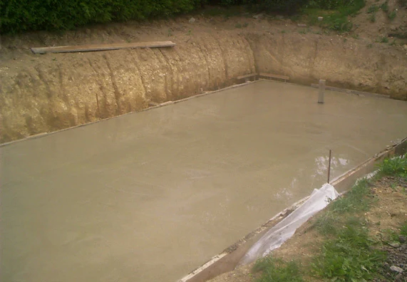 Zatvrzující se betonová podlaha pro svépomocně budovaný bazén.
