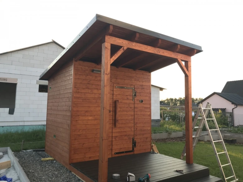 Dřevěná finská sauna v stavbě s otevřenou terasou.