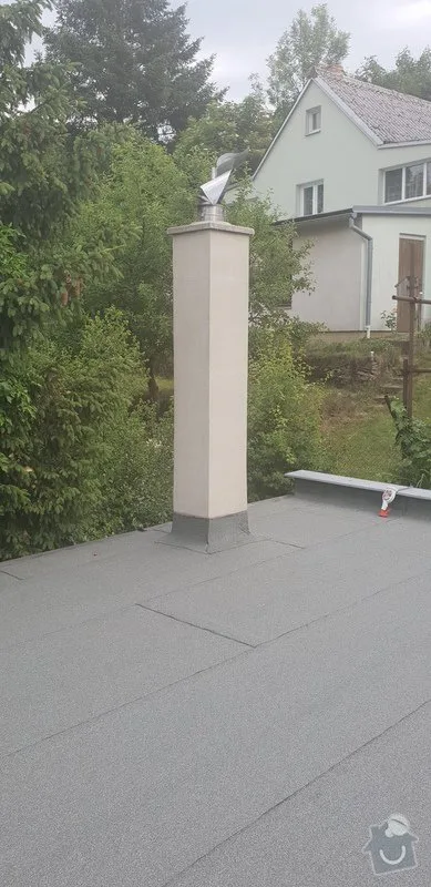 Nově nainstalovaný hromosvod na ploché střeše s okolní zeleňí.
