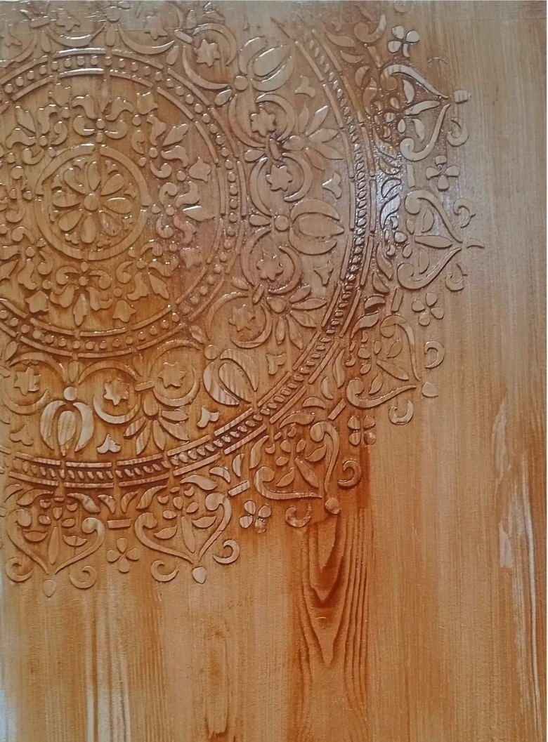 Detailní reliéfní řezba květinového motivu na povrchu dveří.