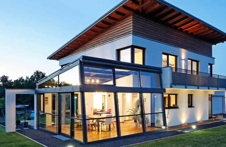 Moderní zimní zahrada připojená k domu s výhledem do interiéru.
