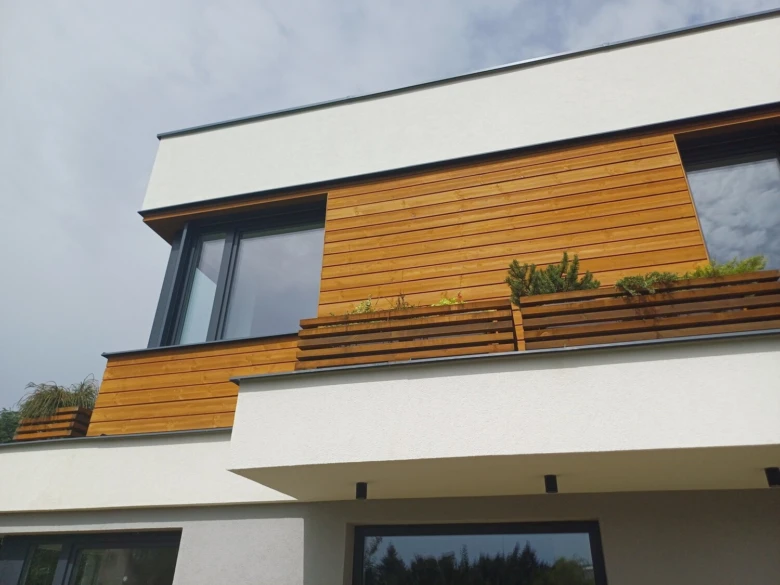 Moderní větraná fasáda s dřevěním na balkóně moderního domu.